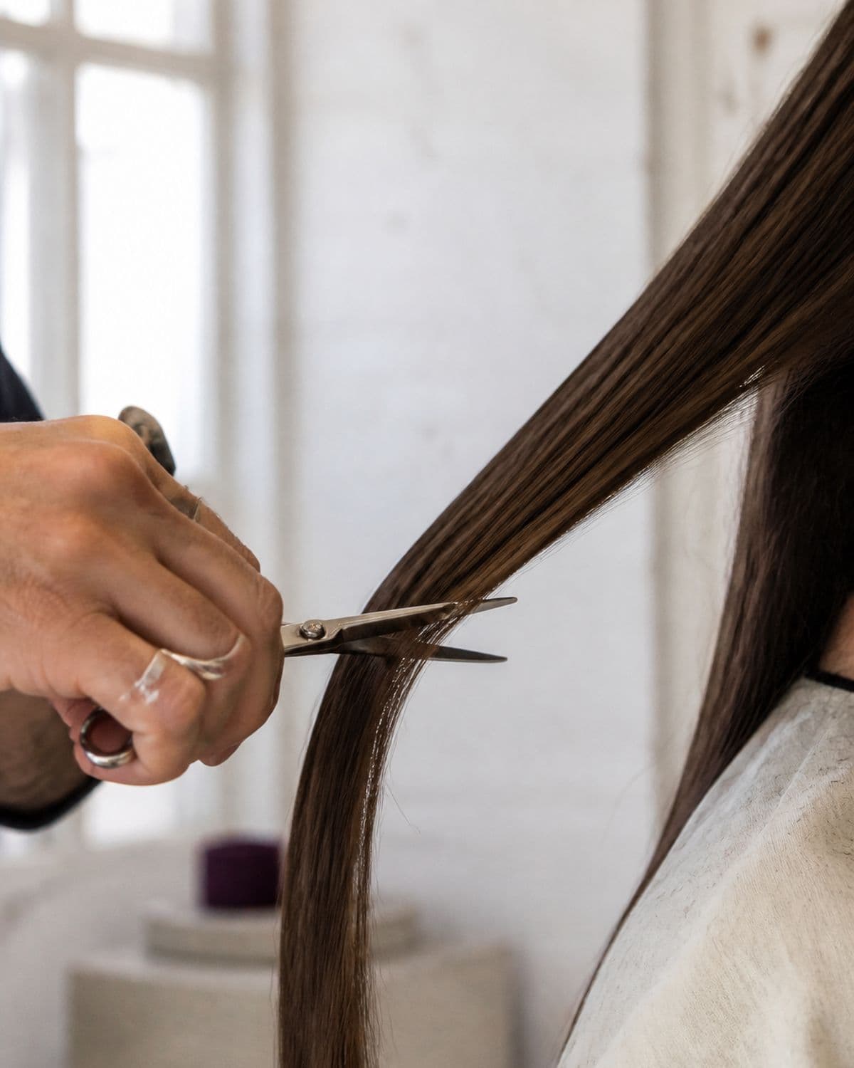Scissors cutting through a clean section of hair